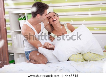 Young love couple in bed with feathers