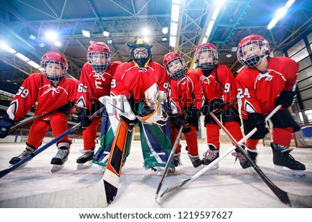 young children playing ice hockey on the rink