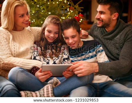 Happy family time – smiling family using digital tablet on Christmas holidays