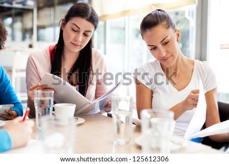 two teenagers students study in cafe