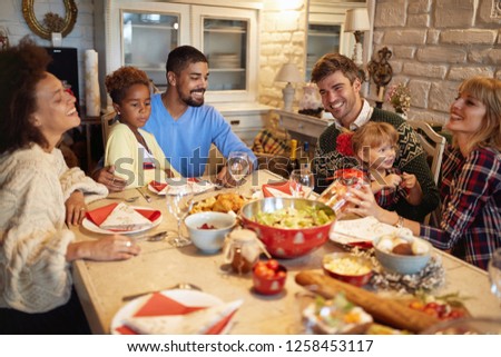 Smiling multi ethnic friends have fun at a family Christmas dinner