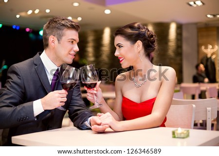 happy affectionate couple at restaurant toasting and looking at each other