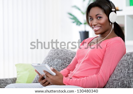 African girl listen to music through digital tablet