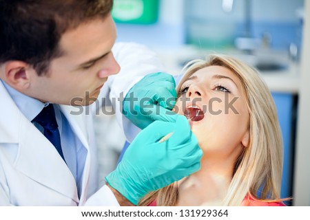 Young female patient takes a dental attendance in the dentist\'s office.