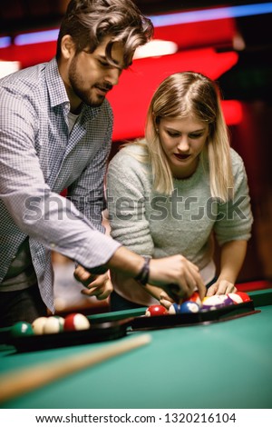 Young couple enjoying in snooker game at pool hall