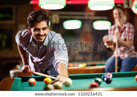 billiard game- smiling man playing snooker in club