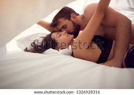 passionate young loving couple in bedroom- making love