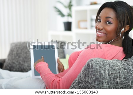 Smiling black woman pointing in tablet pc
