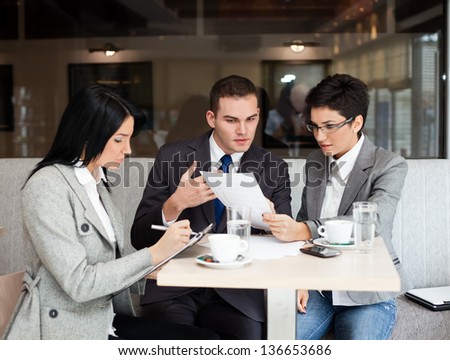 Young business people working over a paperwork and drinking coffee