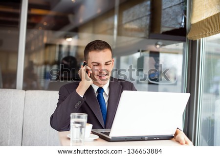 Businessman sitting at table in cafe and working
