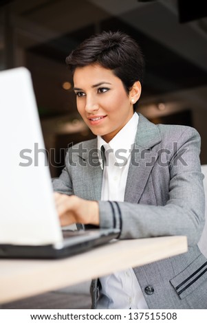 Young woman working on  laptop, she\'s sitting in restaurant