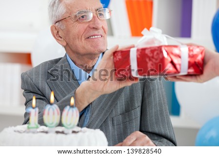senior man receiving gift for birthday