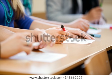 Close-Up Of Writing Hands Of Students At Course