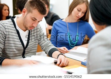 young students studying together in classroom