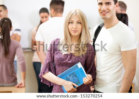 girl and man students with books and a group of students in background