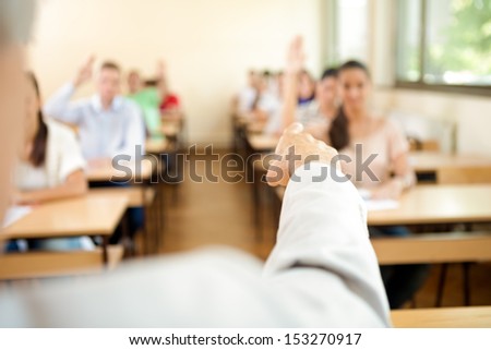 Teacher examines students, pointing with hand