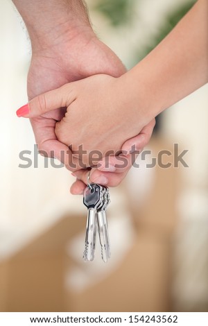Couple hands with key of new home