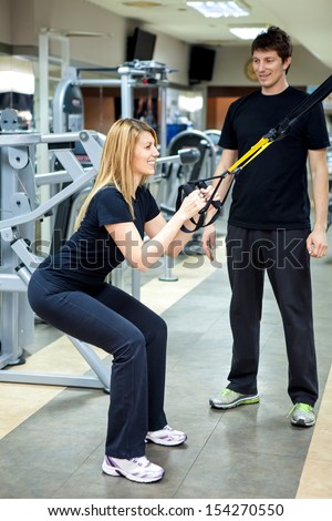 woman in the fitness gym working out with personal trainer coach