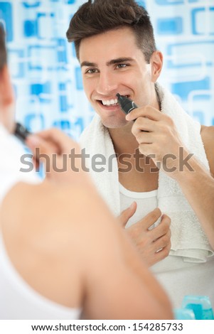 Man using  trimmer to remove hair from his nose