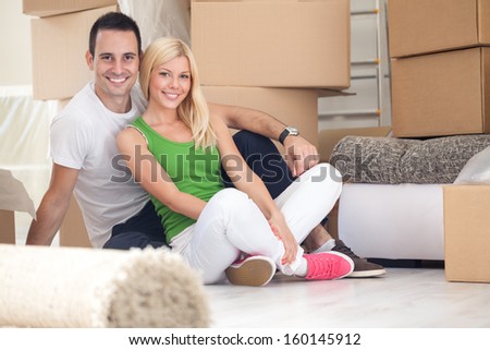 Adorable Couple Sitting On Floor Of Their New Home