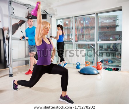 Sporty woman exercising  with kettle bell at gym