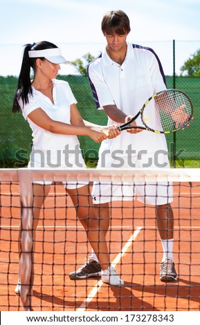 sportswoman with coach practicing tennis