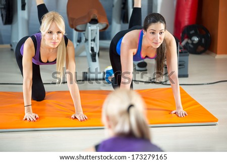 Young active women doing fitness exercises front of mirror