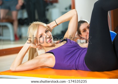 girls doing exercise for stomach muscles in sports club