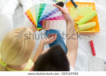 Top view of couple choosing colors to paint new house Top view of couple choosing colors to paint new house