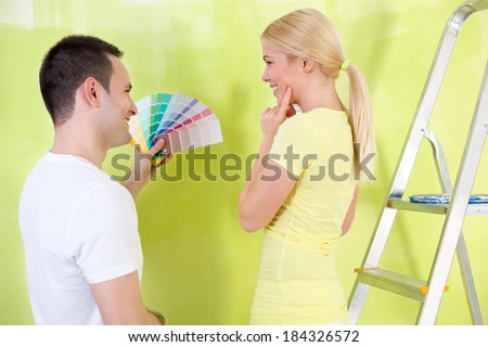 Smiling couple with color samples to paint their new house