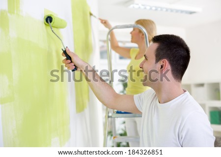 Smiling young couple  painting home