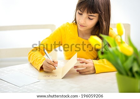 cute little girl making a card for her mom