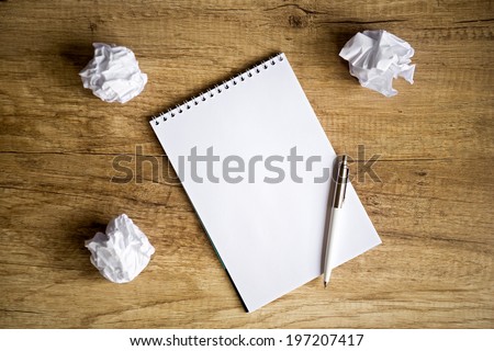 concept - no idea , Empty notebook on wooden table with crumpled papers around