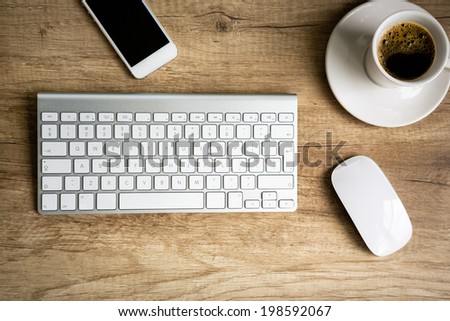 Modern workspace, keyboard and  coffee cup over wooden table