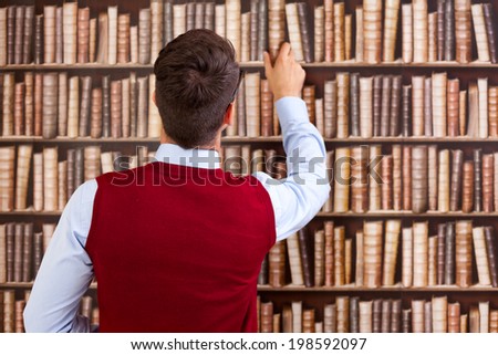 Male student take a book from the shelf in the library