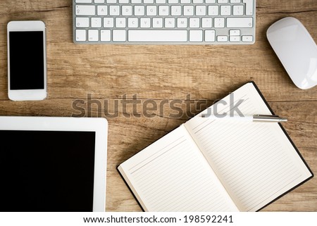 Notebook wit tablet on wooden table, top view