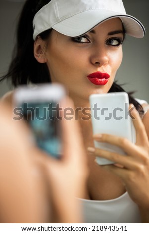 selfie - girl making self portrait with a phone front of the mirror
