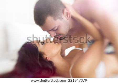 young lovers kissing in bed