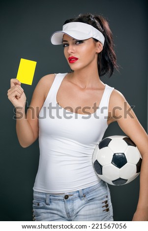 Attractive female football referee football referee punishes with a yellow card