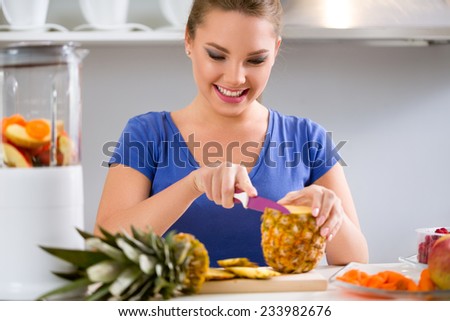 Young smiling woman making fruits smoothies with blender, healthy eating lifestyle concept
