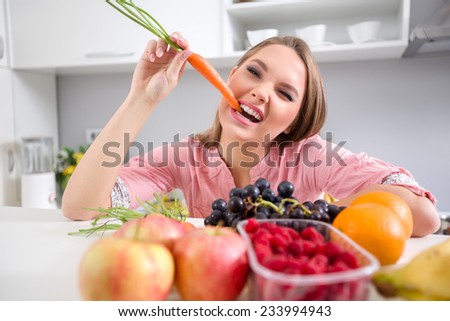 Funny girl biting a carrot, she eating healthy food