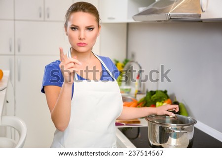 Angry housewife threatening finger, concept you must eat whatever I cook