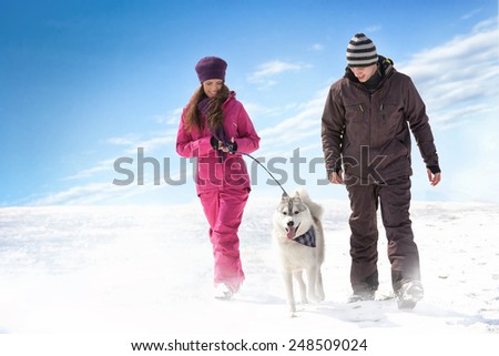 Young couple walking with dog.