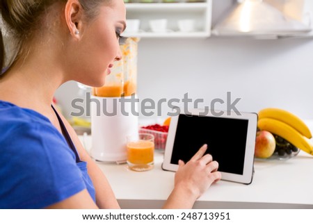Young woman using tablet in kitchen, modern technology and cooking