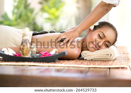 Stone massage, beautiful woman getting spa hot stones massage in spa salon