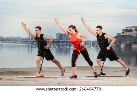 Group of young people doing exercise with resistance rubber