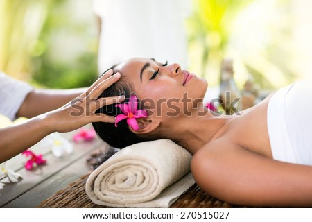 Young woman receiving recreation Balinese massage in spa