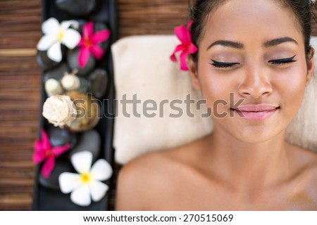 Serene beautiful spa woman relaxing on massage desk