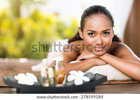 Asian woman in spa salon lying on the massage desk