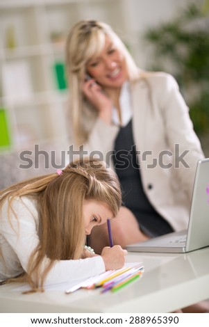 Young cute girl playing while her mom working at home